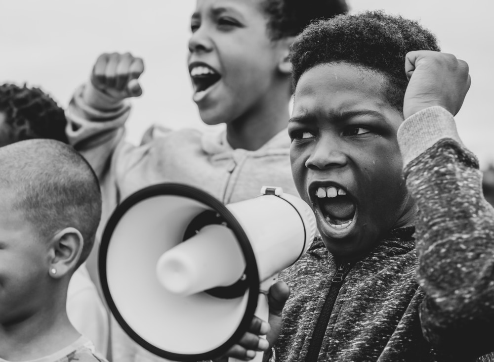 Young boy protesting and shouting into a megaphone