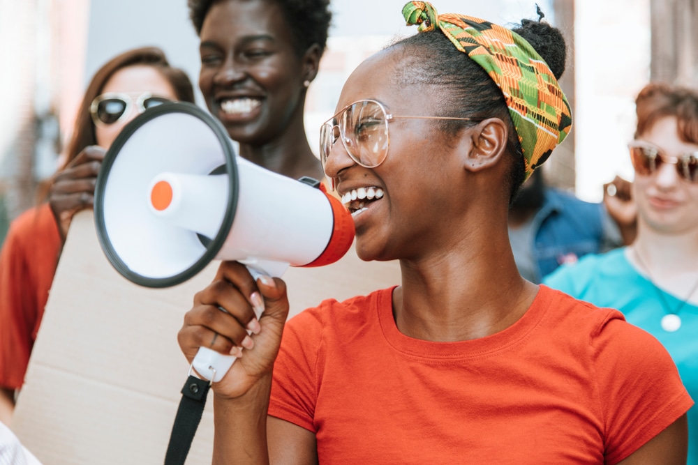 Young women with headband peacefully protesting in Kansas city with a megaphone